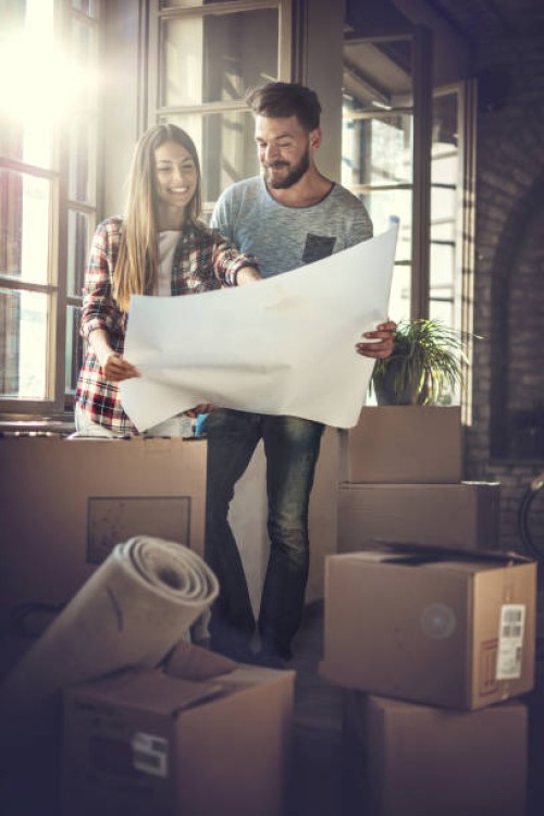 young happy couple looking at renovation plans at their new home. - home decoration stock pictures, royalty-free photos & images