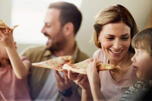young happy family eating pizza for lunch at home. - junk food stock pictures, royalty-free photos & images