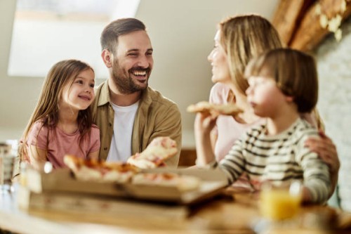 young happy family talking while eating pizza for lunch at home. - junk food stock pictures, royalty-free photos & images