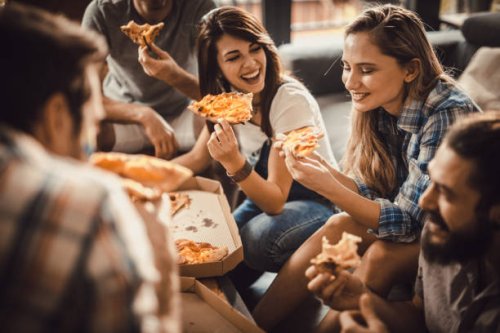 young happy friends having fun while eating pizza at home. - junk food stock pictures, royalty-free photos & images