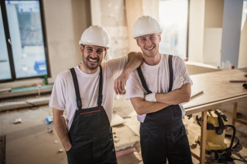 young happy manual workers at construction site. - home decoration stock pictures, royalty-free photos & images