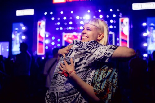 young happy woman embracing her boyfriend during a music festival at night. - concert stock pictures, royalty-free photos & images