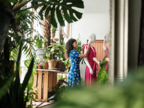 young latin woman putting dress in mannequin - fashion stock pictures, royalty-free photos & images