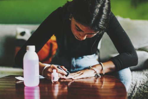young latina f woman with long, slender fingers, paints her nails at home - nails art stock pictures, royalty-free photos & images