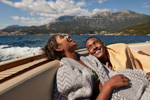 young man and woman laughing in speedboat - travel stock pictures, royalty-free photos & images