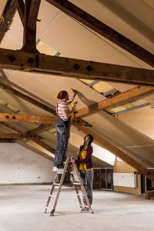 young man and woman mouting insulation on construction site - home decoration stock pictures, royalty-free photos & images