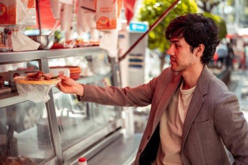 young man buying food at fast food kiosk - junk food stock pictures, royalty-free photos & images