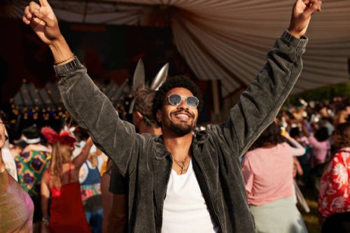 young man dancing with arms raised - concert stock pictures, royalty-free photos & images