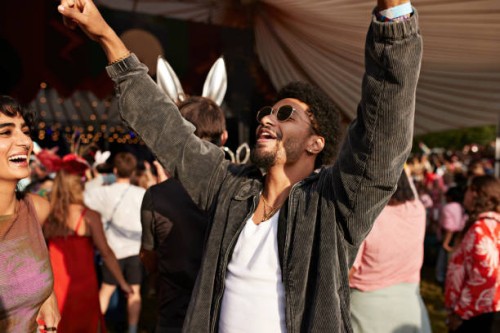 young man dancing with arms raised by girlfriend - concert photos et images de collection