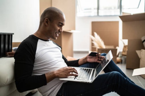 young man doing an online shopping for new home - home decoration stock pictures, royalty-free photos & images