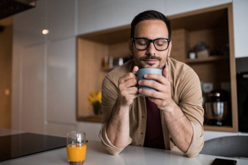 young man drinking his morning coffee at home. - coffee stockfoto's en -beelden