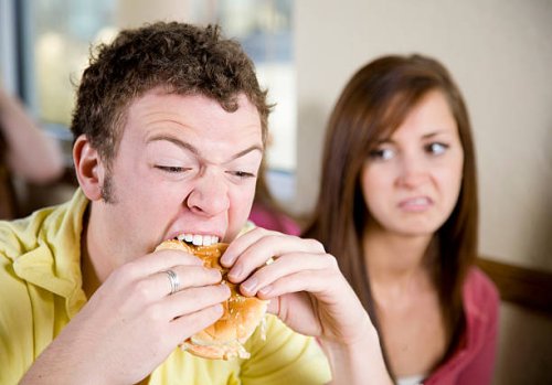 young man eating a cheeseburger - junk food stock pictures, royalty-free photos & images
