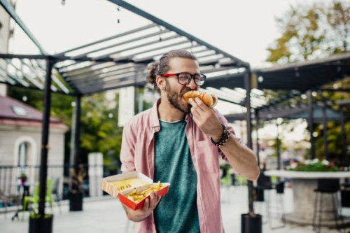young man eating fast food - junk food stock pictures, royalty-free photos & images