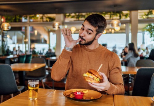 young man enjoying a delicious burger - food stock pictures, royalty-free photos & images