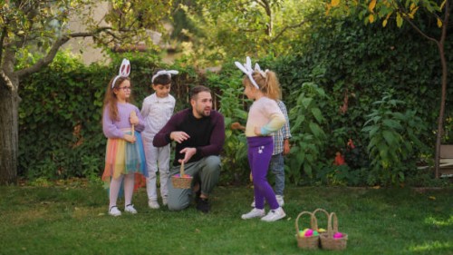 young man explaining egg and spoon race to group of children outdoors - garden decoration stock pictures, royalty-free photos & images