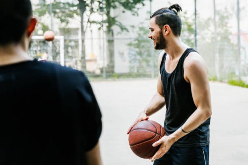 young man holding basketball ready to start the game - hairstyle stock pictures, royalty-free photos & images