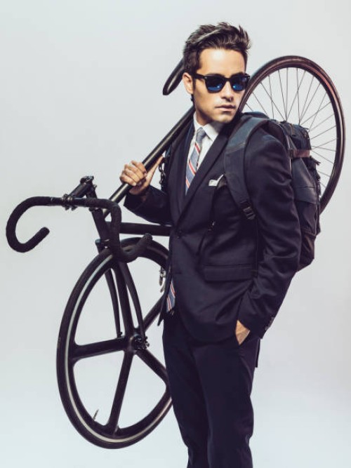 young man in suit with backpack and bike standing on white background - fashion stock pictures, royalty-free photos & images
