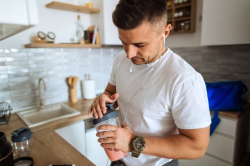 young man making protein shake before training - food stock pictures, royalty-free photos & images