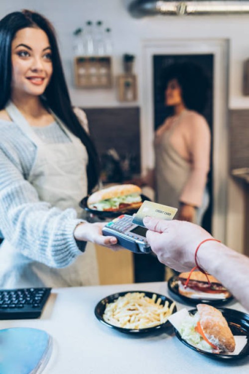young man paying with credit card in fast food restaurant - junk food stock pictures, royalty-free photos & images