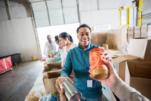 young man receives food donations in food bank - food stock pictures, royalty-free photos & images