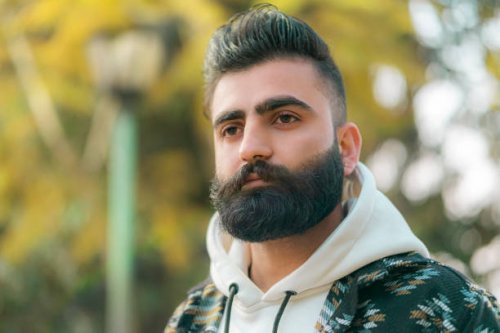 young man stands in the park. - hairstyle stock pictures, royalty-free photos & images