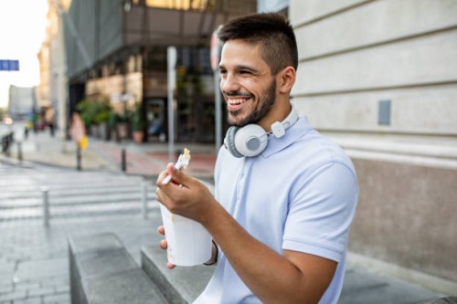 young man taking a break and eating fast food - junk food stock pictures, royalty-free photos & images