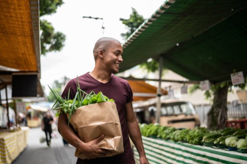 young man walking in a street market - food stock pictures, royalty-free photos & images