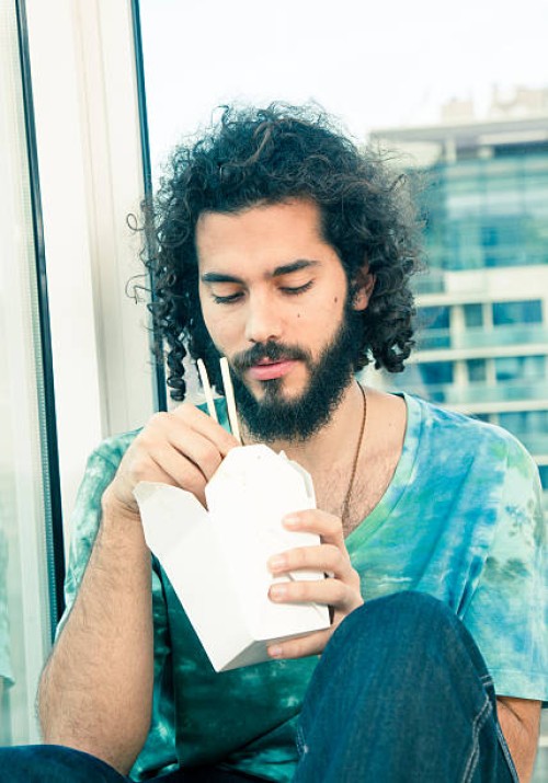young man with chinese takeout - junk food stock pictures, royalty-free photos & images