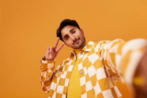 young man with vitiligo gesturing peace sign - fashion stock pictures, royalty-free photos & images