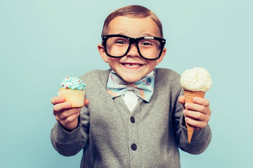 young nerd boy holds ice cream and cupcakes - junk food stock pictures, royalty-free photos & images