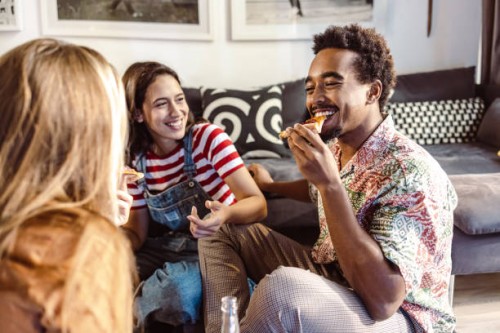 young people in casual clothes eating pizza, talking, and laughing - junk food stock pictures, royalty-free photos & images