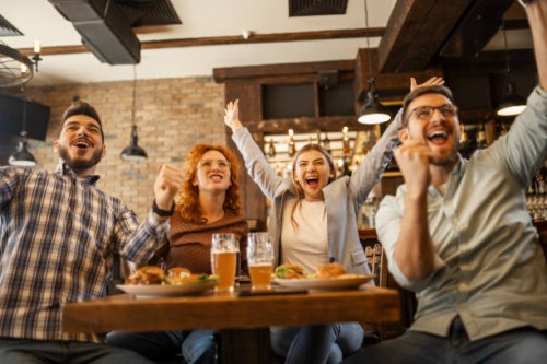young people watching soccer game in pub cheering during goal - food stock pictures, royalty-free photos & images