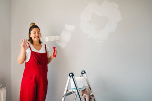young pregnant woman painting nursery and having fun - home decoration stock pictures, royalty-free photos & images