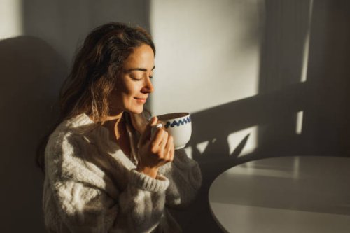 young pretty woman enjoying morning coffee at home. beautiful sun light in kitchen room. - coffee stock pictures, royalty-free photos & images