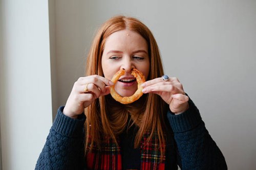 young red haired woman eating junk food - junk food fotografías e imágenes de stock
