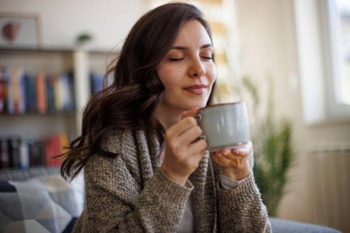 young smiling woman enjoying in smell of fresh coffee at home - coffee stock pictures, royalty-free photos & images