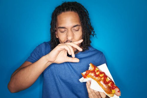 young urban man eating hotdog - junk food stock pictures, royalty-free photos & images