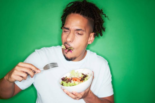 young urban man eating salad - food stock pictures, royalty-free photos & images