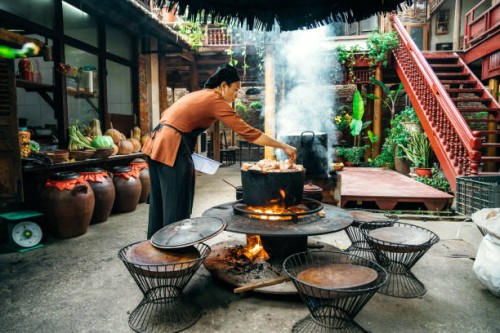 young vietnamese woman cooking steamed fish on open fire in restaurant - food stock pictures, royalty-free photos & images