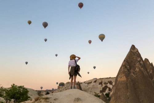young woman and hot air ballons, goreme, cappadocia, turkey - travel stock pictures, royalty-free photos & images