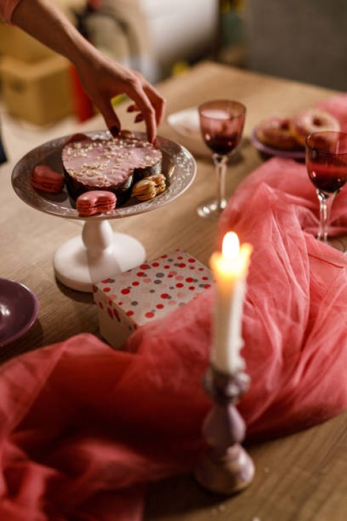 young woman arranging heart shaped macaroons around a cute small cake - home decoration stock pictures, royalty-free photos & images