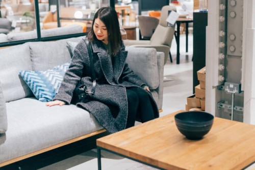 young woman at furniture store choosing sofa - home decoration stock pictures, royalty-free photos & images