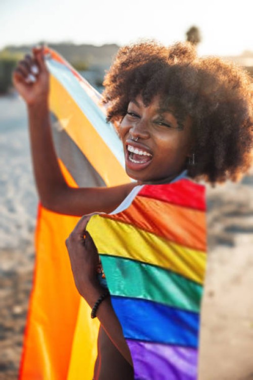young woman at lgbtqia parade on the beach smiling to camera - concert stock pictures, royalty-free photos & images