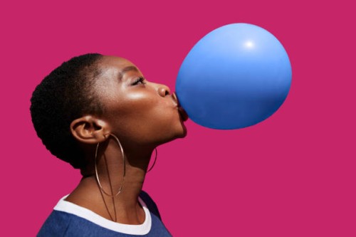 young woman blowing balloon against pink background - fashion stock pictures, royalty-free photos & images