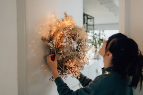 young woman decorating her living room for the upcoming holidays - home decoration stock pictures, royalty-free photos & images