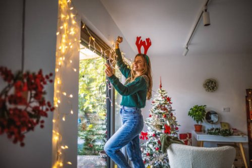 young woman decorating home for the upcoming holidays - home decoration stock pictures, royalty-free photos & images