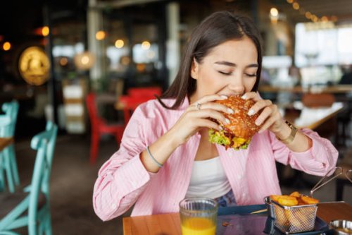 young woman dining in fast food restaurant - junk food stock pictures, royalty-free photos & images