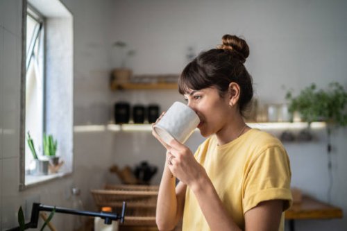 young woman drinking coffee or tea at home - coffee stock pictures, royalty-free photos & images