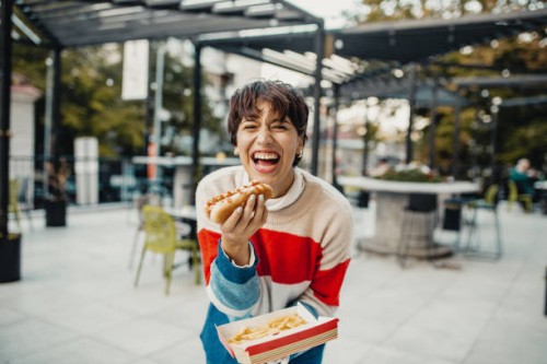 young woman eating fast food - junk food stock pictures, royalty-free photos & images