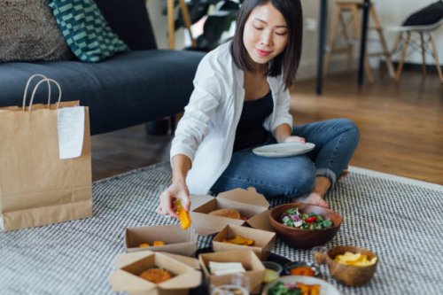 young woman eating fast food at home - junk food stock pictures, royalty-free photos & images